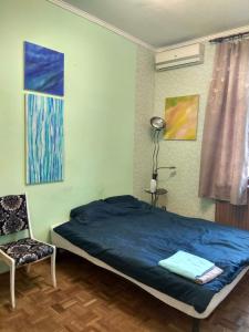 a bedroom with a blue bed and a chair at Alabama in Kyiv
