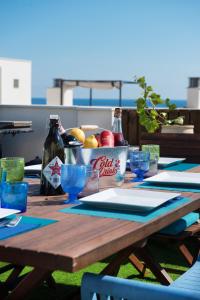 a wooden table with glasses and bottles on it at NEW APARTMENT WITH BIG TERRACE 10 Min WALK TO BEACH SUPERMARKETS in Calafell
