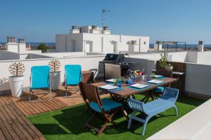 a patio with a table and chairs on a roof at NEW APARTMENT WITH BIG TERRACE 10 Min WALK TO BEACH SUPERMARKETS in Calafell