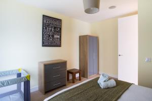 a bedroom with a bed and a dresser and a mirror at Luxury Apartment Marina Views at Titanic Quarter in Belfast