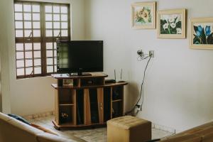 ein Wohnzimmer mit einem Flachbild-TV auf einem Stand in der Unterkunft Casa em Capitólio - Escarpas do Lago in Capitólio