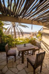 Une table et des chaises en bois sont disponibles sur la terrasse. dans l'établissement Desert Home, à Mitzpe Ramon