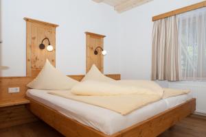 a bedroom with a bed with white sheets and a window at MY APARTMENT krinzwald in Seefeld in Tirol