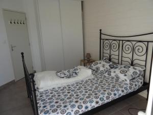 Bett mit blauer und weißer Bettwäsche und Kissen in der Unterkunft Plouguerneau - maison à 200 m de la mer in Plouguerneau