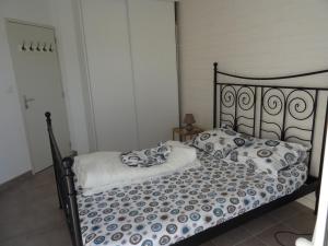 a bed with blue and white sheets and pillows at Plouguerneau - maison à 200 m de la mer in Plouguerneau