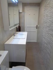 a white bathroom with a sink and a toilet at Charming Apartment on the boarder of Monaco in Beausoleil