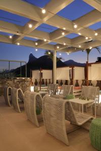 un patio con mesas y sillas de mimbre por la noche en Yoo2 Rio de Janeiro by Intercity en Río de Janeiro