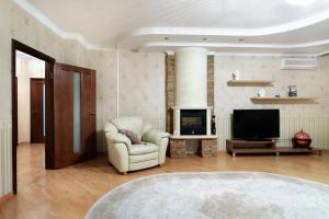 a living room with a chair and a television at PaulMarie Apartments on Mira in Mogilev