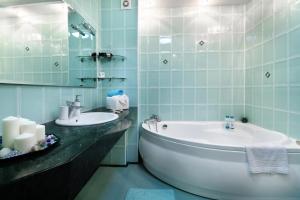 a bathroom with a tub and a sink at PaulMarie Apartments on Mira in Mogilev