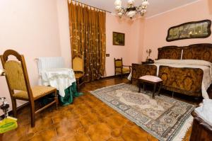 a bedroom with a bed and a table and chairs at B&B La Volpara in Trasacco