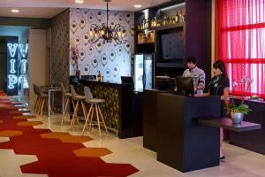 two people standing at a bar in a restaurant at ibis Styles Ribeirao Preto Braz Olaia in Ribeirão Preto