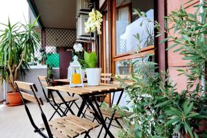 a table and chairs on a patio with plants at TRASTEVERE COZY FLAT 8 PEOPLE in Rome