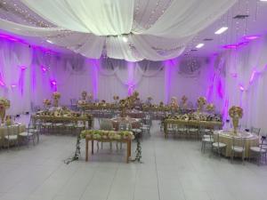 a banquet hall with tables and chairs and purple lighting at Terra Toscana Hotel in Mangue