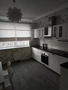 a kitchen with white cabinets and a stove top oven at Comfort Apartment on Bogdanivska street 7b in Kyiv