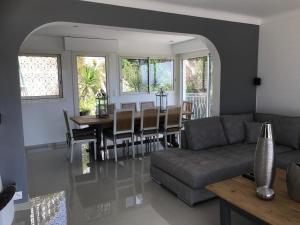 a living room with a couch and a dining room table at Villa La Riviera in Mandelieu-la-Napoule
