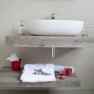 een wastafel en handdoeken op een houten plank met een wastafel bij ML House in Costa Volpino