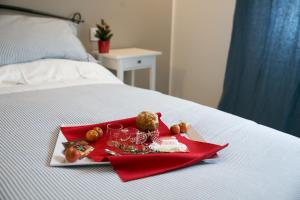 a tray with wine glasses and fruit on a bed at ML House in Costa Volpino