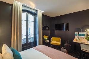 a hotel room with a bed and a television at Mercure Nantes Centre Passage Pommeraye in Nantes