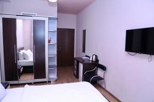 a hotel room with a bed and a tv on the wall at Taste Tbilisi in Tbilisi City