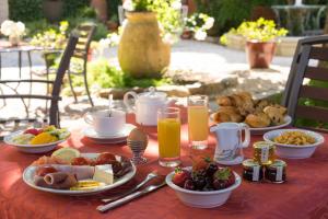 een tafel met borden en glazen sinaasappelsap bij Hôtel La Casa Pairal in Collioure