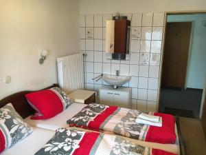 DonzdorfにあるMonteurzimmer im Schwabenlandのベッド2台とシンクが備わる小さな客室です。
