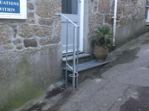 a potted plant sitting on the steps of a door at Sunny Corner in Mousehole