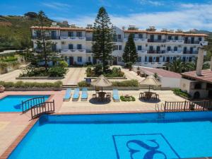 una piscina con un hotel sullo sfondo di Spiros-Soula Family Hotel & Apartments ad Agia Pelagia