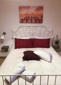 uma grande cama branca com almofadas vermelhas em Casa Maria em Vietri