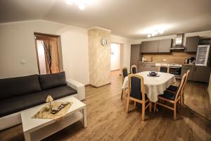 a living room with a couch and a table and a kitchen at Landhaus zur Tanne in Feld am See