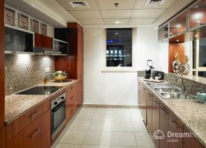 a large kitchen with wooden cabinets and stainless steel appliances at Dream Inn Apartments - Marina Quays in Dubai