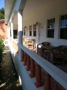 a balcony of a house with chairs and a table at Polish Princess Guest House in Port Antonio