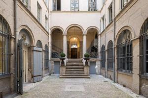 an alleyway in a building with stairs in the middle at 21Royale in Lyon