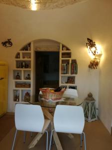 Zimmer mit 2 weißen Stühlen und einem Tisch in der Unterkunft Trullo Nonna Mari in Cisternino