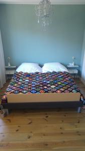 a bed with a colorful quilt on it in a bedroom at Sfeervolle woning dichtbij centrum Deventer in Deventer