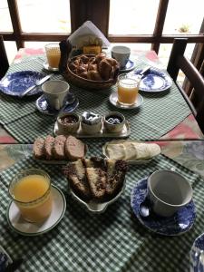 una mesa con tazas y platos de comida y pan en Posada del Angel en San Carlos de Bariloche