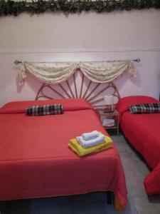 a bedroom with two beds with red sheets at Palazzo Ruisi in Scordia