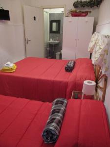 two beds in a room with red sheets at Palazzo Ruisi in Scordia