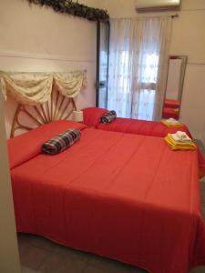 a bedroom with two beds with red sheets at Palazzo Ruisi in Scordia