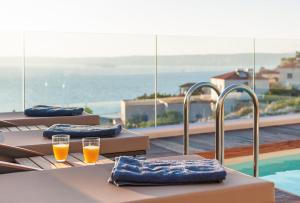 a row of tables with glasses of orange juice on a balcony at Villa Vamagia BY APOKORONAS-VILLAS in Plaka