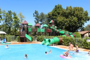 a group of people in a swimming pool at a water park at Chateau-camping la Grange Fort, 63500 Les Pradeaux in Les Pradeaux