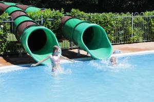 deux jeunes filles jouant dans une piscine dans l'établissement Chateau-camping la Grange Fort, 63500 Les Pradeaux, à Les Pradeaux