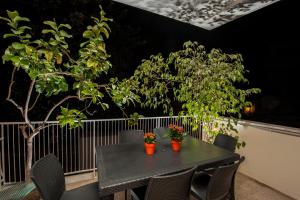 un tavolo nero con sedie e un albero sul balcone di Vatican Meadows a Roma