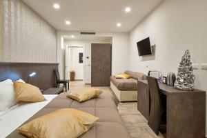 een slaapkamer met 2 bedden en een woonkamer bij Ricaroka Hotel in Albenga