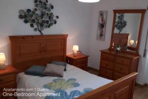 a bedroom with a bed and two dressers and a mirror at Akicity Sintra Moss in Sintra