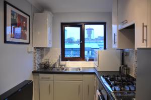 プリマスにあるWaterside flatのキッチン(シンク、コンロ付)、窓が備わります。