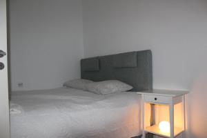 ハープサルにあるNiine Apartmentのベッド(ヘッドボード付)、テーブル(ランプ付)