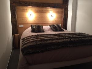 Una cama con dos almohadas encima. en LA BRESSE - Appartement de Charme en La Bresse