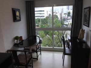 a room with a table and chairs and a large window at The Avenue Residences in Pattaya