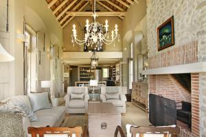 a living room with a brick fireplace and a chandelier at Villa Simondium in Franschhoek
