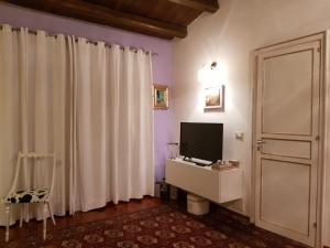 a living room with a television and a white curtain at Sguardo Sul Barocco in Ragusa